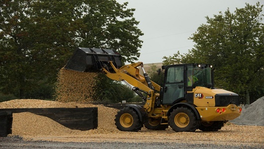 Compact wheel loader CAT 908M digging hole
