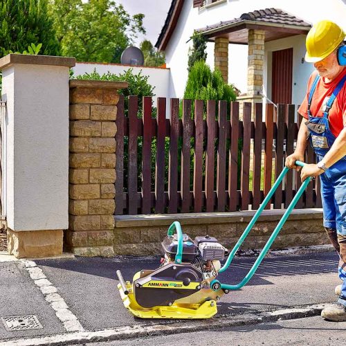 Vibratory plate AMMANN (69 kg) in use on sidewalk
