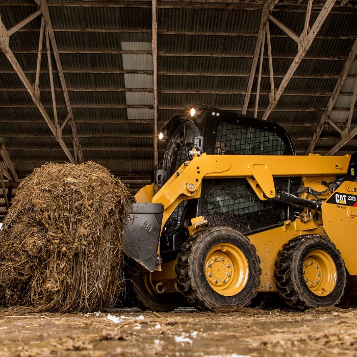 Skid steer loader CAT 226D lifting hay